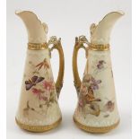 A pair of Royal Worcester blush ivory ewers, decorated with flowers and butterflies, bearing