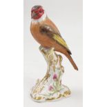 A Royal Worcester model, Goldfinch, on a gilt and white stump decorated with flowers, model number