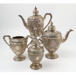 A silver plated four piece tea set, elaborately decorated with scrolls,