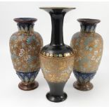 A pair of Royal Doulton stoneware vases, decorated with turquoise and gilt flowers to a gold ground,