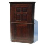 An Antique oak floor standing double corner cupboard, with panelled doors,