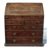 An Antique oak bureau, the fall flap opening to reveal drawers, pigeon holes and a well,