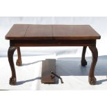 An Edwardian mahogany extending dining table, raised on four heavy cabriole legs,