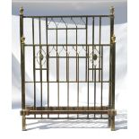 A pair of Art Nouveau brass bed ends, with arcaded decoration and mounted finials,