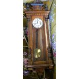 A 19th century walnut cased Vienna style wall clock, with white enamel dial and Roman numerals,