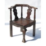 An 18th century design oak corner chair, with carved seat,