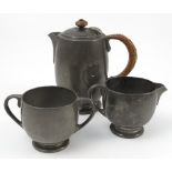 A Liberty Tudric three piece tea set, with wicker handle,