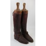 A pair of brown leather riding boots, with laces,