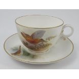 A Royal Worcester oversize cup and saucer, the cup decorated with a grouse in flight over foliage,