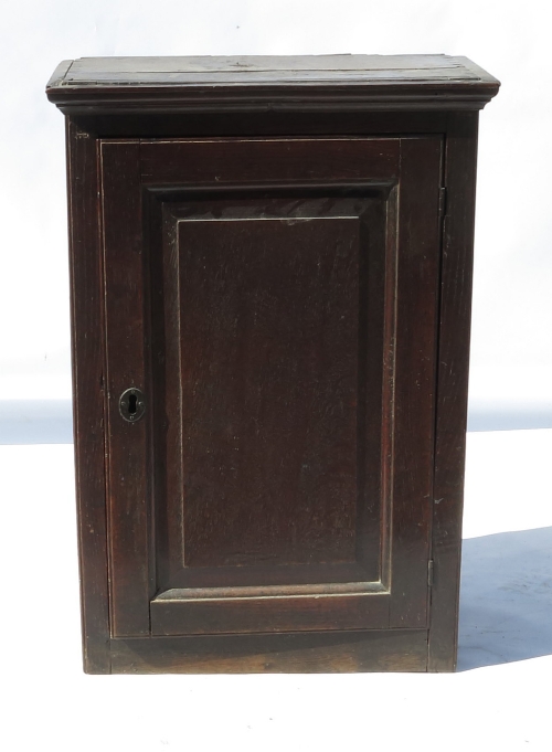 An 18th century oak wall cupboard, the panelled door opening to reveal fitted shelves, width 20.