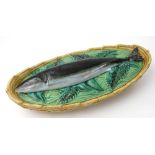 A 19th century English majolica oval fish dish, the lid moulded with a fish on greenery,