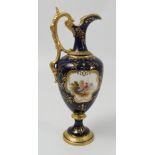 A Coalport ewer, decorated with a fabulous bird in landscape to a blue and gilt ground, height 9.