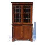 An Empire design mahogany bookcase cupboard, the upper section fitted with two glazed doors,