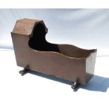 An Antique oak baby's crib, of rectangular form, with shaped edge and foot to one end,