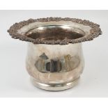 A 19th century silver plated bottle coaster, with embossed gadrooned and floral edge,