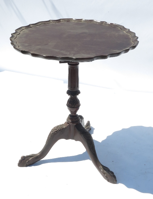 A Georgian design occasional table, with pie crust top with birdcage below, raised on a tripod base,