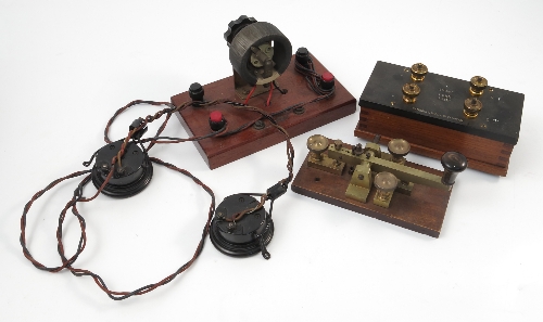 A brass morse code machine, on mahogany base,