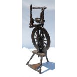 An Antique spinning wheel, with turned decoration, raised on three turned legs,