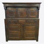 A late 17th century oak court cupboard, having three panelled doors to the canopied upper section,