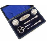 A cased silver manicure set, comprising two glass and silver topped bottles, a nail buffer,