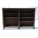 A Jacobean style oak bookcase, of two division form, with adjustable shelves with guilloche carving,