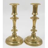 A pair of 19th century brass candlesticks with knopped stems and circular bases,