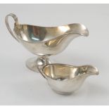 A silver sauce boat, with ribbed handle, raised on an oval pedestal foot with ribbed edge,