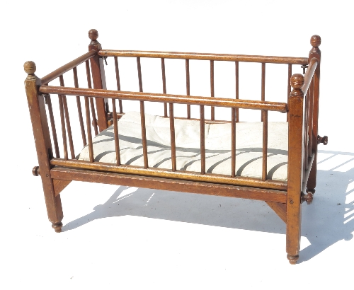 A child's dolls cot, with turned spindle supports,