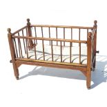 A child's dolls cot, with turned spindle supports,