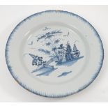 A Delft tin glazed plate, decorated with flowers and a fence, in blue and white diameter 13.