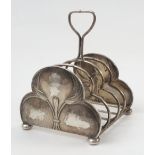 A Guild of Handicrafts silver five bar toast rack, the end bars of triform embossed with leaves,