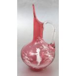 A 19th century cranberry glass jug, decorated in the Mary Gregory style with a child and ferns,