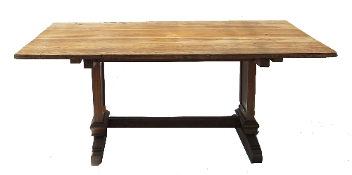 A large oak rectangular dining table, raised on two solid ends with sledge feet,