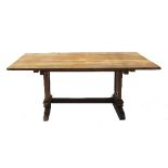 A large oak rectangular dining table, raised on two solid ends with sledge feet,