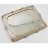 A silver tray, of rectangular form, with gilt wash to a shaped edge and engraved border,