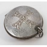 A silver circular wafer box, engraved with a cross to the lid with rope border and hammered finish,