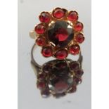 An eleven stone garnet cluster ring, stamped '585', finger size U1/2, weight 6.