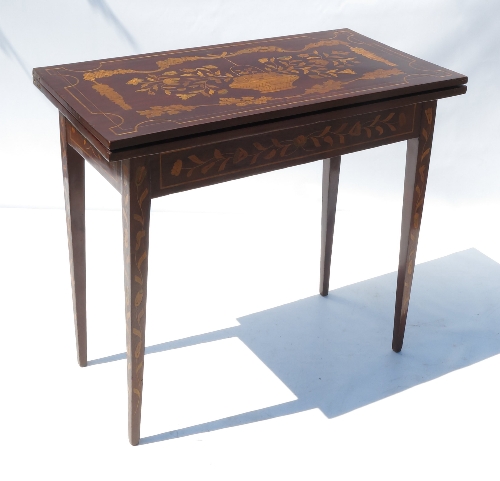 A rectangular shaped mahogany foldover games table, raised on four square tapering legs,