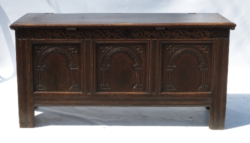 An Antique oak coffer, having three arched carved panels to the front with a plain rising lid,