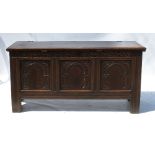 An Antique oak coffer, having three arched carved panels to the front with a plain rising lid,