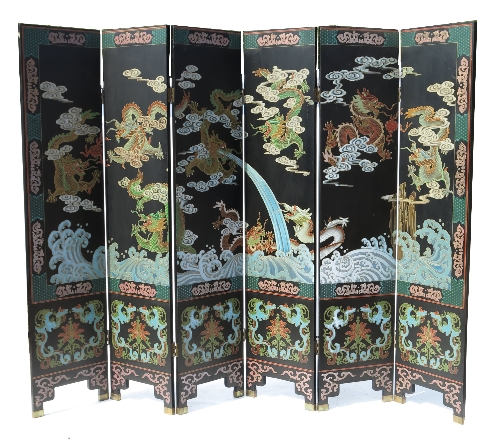 An ebonised Oriental six fold screen, decorated in the Chinese style, with dragons,