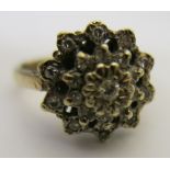 A 9ct gold diamond cluster ring, the central stone being surrounded by two stepped bands of stones,