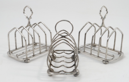 A pair of five bar silver toast racks, with angular bars and raised on oblate bun feet,