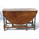 An Antique oak oval gate leg dining table, fitted with an end drawer, raised on turned legs,