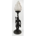 A spelter lamp base, formed as a cavalier soldier holding a flaming torch, with glass flame shade,