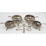 A pair of silver open circular salts, with embossed floral decoration raised on three outswept feet,