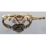 A diamond set hinged bangle, the trefoil motif flanked by wing like motifs,