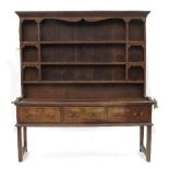 An Antique oak dresser, with close boarded Delft rack over, fitted three frieze drawers,