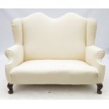 A Georgian design camel back sofa, raised on short cabriole legs,