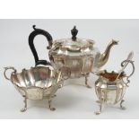 A silver three piece tea set, the fluted body with c scroll edge,